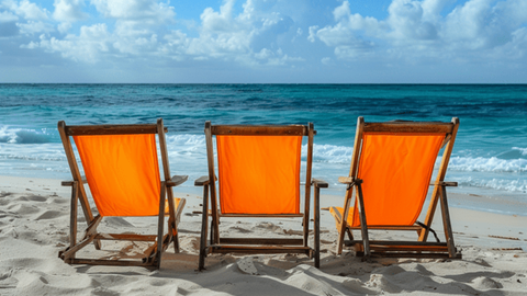 Three orange canvas beach chairs sitting on a beach next to each other