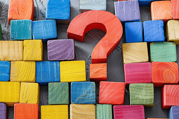 A wooden question mark surrounded by colored wooden blocks