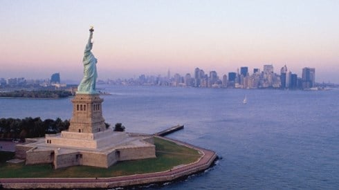 An aerial view of the Statue of Liberty, waterways around it, and New York City