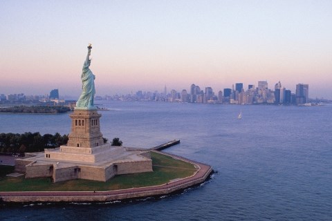An aerial view of the Statue of Liberty, waterways around it, and New York City