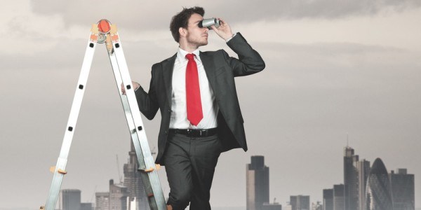 Businessman on an A-frame ladder looking through binoculars with a city skyline in the background