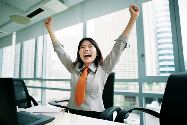 Happy businesswoman celebrates because of some accomplishment on her laptop