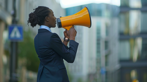 Businesswoman using a megaphone while standing outside