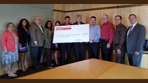 CICA team presents large carton check in boardroom as leading financial supporter