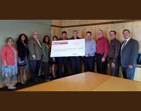 CICA team presents large carton check in boardroom as leading financial supporter