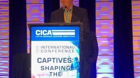 Gary Bowers presenting on stage behind podium at CICA 2019 conference