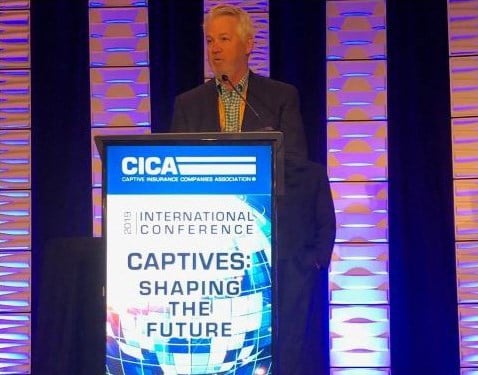 Gary Bowers presenting on stage behind podium at CICA 2019 conference