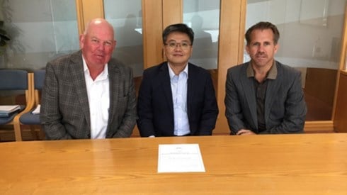 Three businessmen sitting at a board table