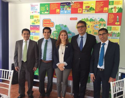 Five business professionals standing in front of colorful infographic art