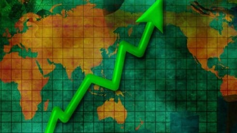 Green jagged arrow and bar chart rising sharply on top of world map