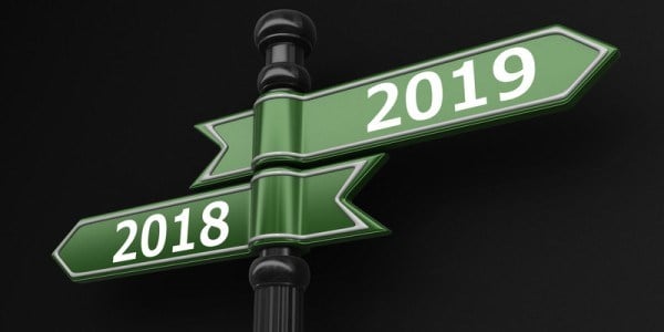 Street sign pole with 2 green arrows marked 2018 pointing left and 2019 pointing right
