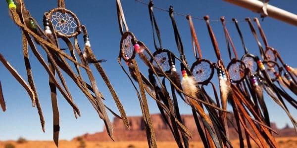 Dreamcatchers hung in a row with a desert plateau in the background