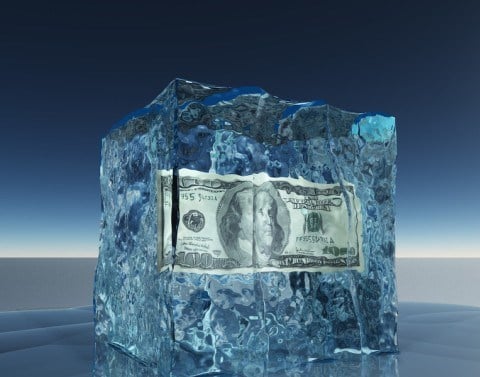 A 100 dollar bill frozen in a block of ice