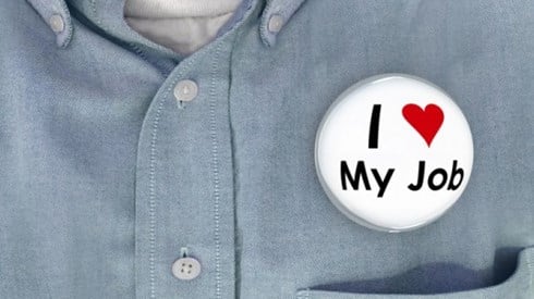 Closeup of a man´s shirt with a bubble pinback button that says I Love My Job with love symbolized by a red heart