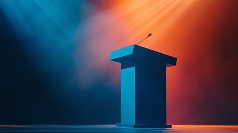 Orange and blue lights shining on a podium with a microphone