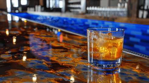 Glass of whiskey on the rocks sitting on a bar top