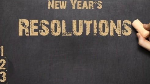 A hand writing on a New Year´s Resolutions list of items 1, 2 and 3