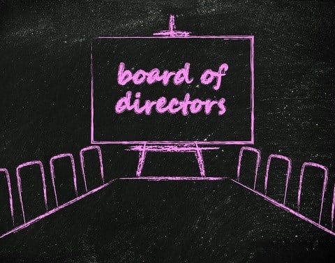 A pink chalk drawing of a board meeting room table and chairs and a blackboard on an easel with the words board of directors