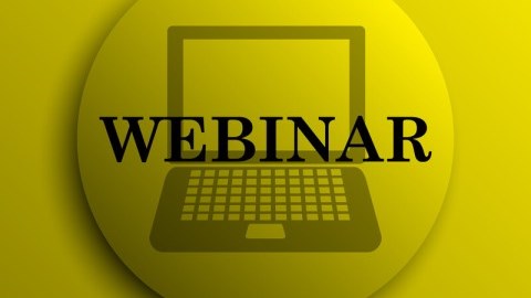 Yellow pinback button with a laptop silhouette in the background and the word WEBINAR in the foreground