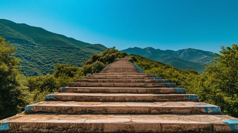A stone staircase leading up through verdant mountains