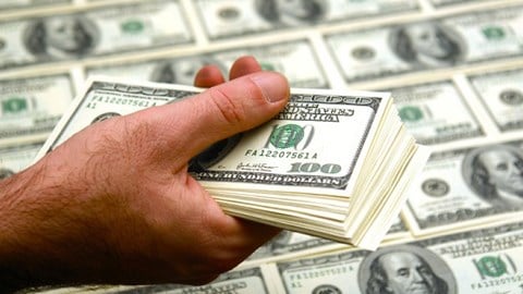 Man Holding Stack Of Hundred Dollar Bills Over Money