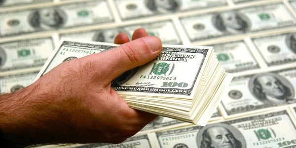 Man Holding Stack Of Hundred Dollar Bills Over Money