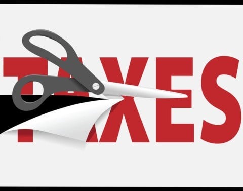 Scissors cutting through the word taxes