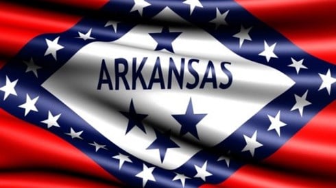 The flag of Arkansas is a red flag with a white diamond surrounded by a blue diamond, 29 stars, and the word ARKANSAS on it