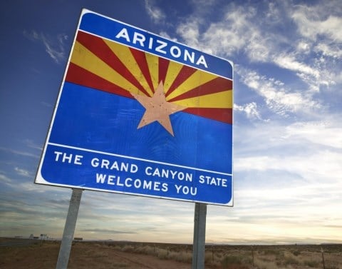 A welcome sign at the border of Arizona saying ARIZONA and THE GRAND CANYON STATE WELCOMES YOU