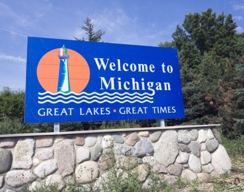Welcome to Michigan sign with lighthouse, lake icon and the words GREAT LAKES, GREAT TIMES