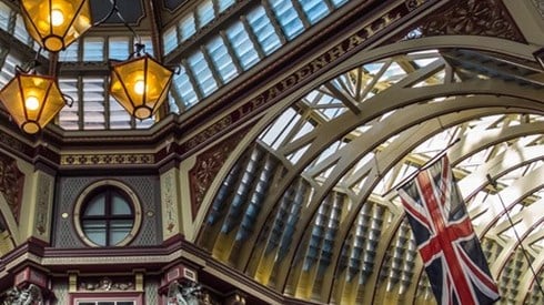 Inside ceiling view of the UK Leadenhall Market building with the British flag hanging on the right