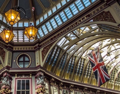 Inside ceiling view of the UK Leadenhall Market building with the British flag hanging on the right