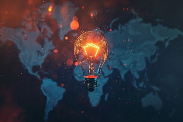 A glowing light bulb in front of a world map background