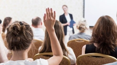 College Student Raising Hand at Conference