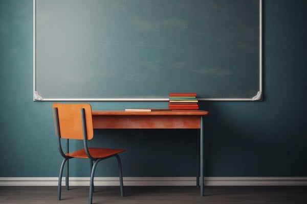 School desk sitting in front of chalkboard