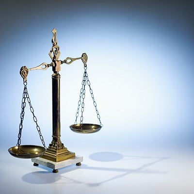 Legal scales of justice on blue gray background