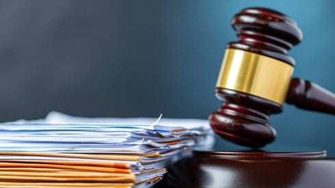 A gavel next to a stack of documents