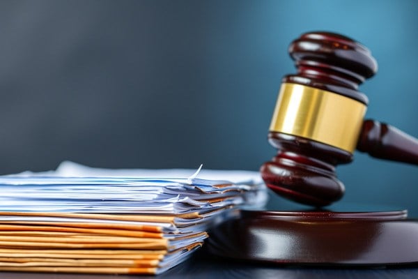 A gavel next to a stack of documents