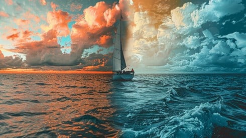 A sailboat on an ocean with half of the background one color and the other half a different color