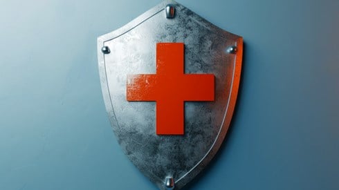 Metal shield with red medical cross symbol emblazoned on it