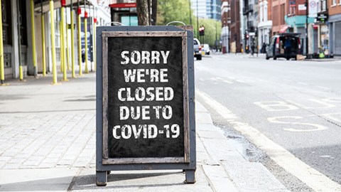Store sidewalk sign reads Sorry we're closed due to COVID-19