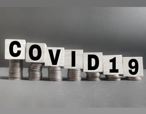 A building block for each letter of the term COVID19 is on top of a stack of coins descending in height