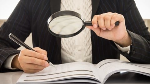 Business Woman Looking At Booklet With Magnifying Glass
