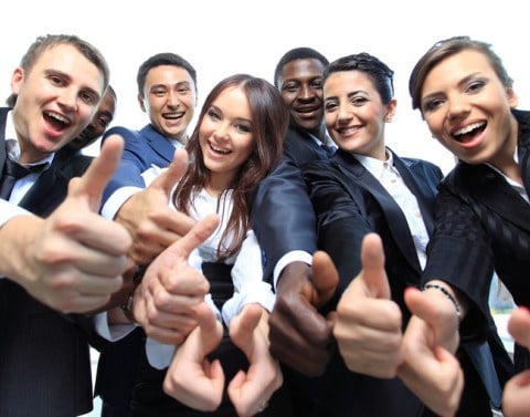 Smiling young business professionals giving thumbs up