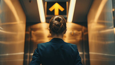 View from behind of a businesswoman going up in an elevator