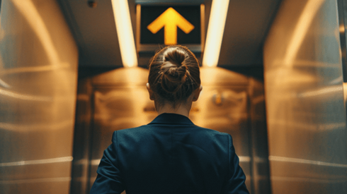 View from behind of a businesswoman going up in an elevator