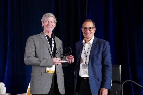 Business Insurance Publisher Keith Kenner presents ICCIE Executive Director Mitch Cantor with a special commemorative award to mark ICCIE's 20th Anniversary at World Captive Forum 2024
