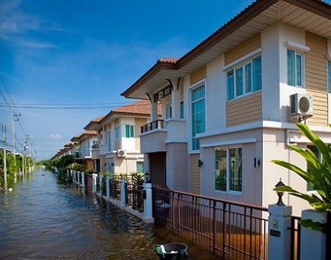 Residential street with two story buildings with flood waters nearing the ground floor