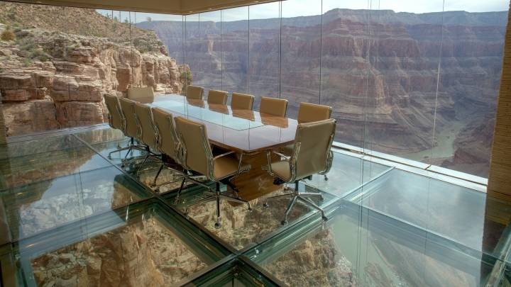 conference table and chairs on a glass floor over the Grand Canyon