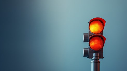 Red and yellow traffic light against a blue background
